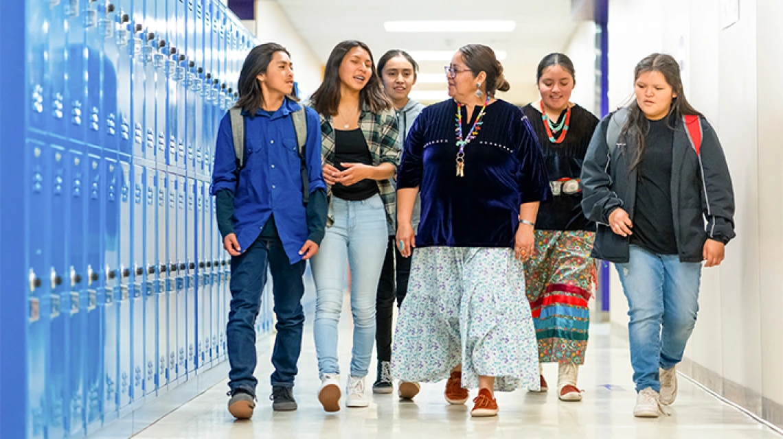 Profesor caminando con un grupo de estudiantes por el pasillo
